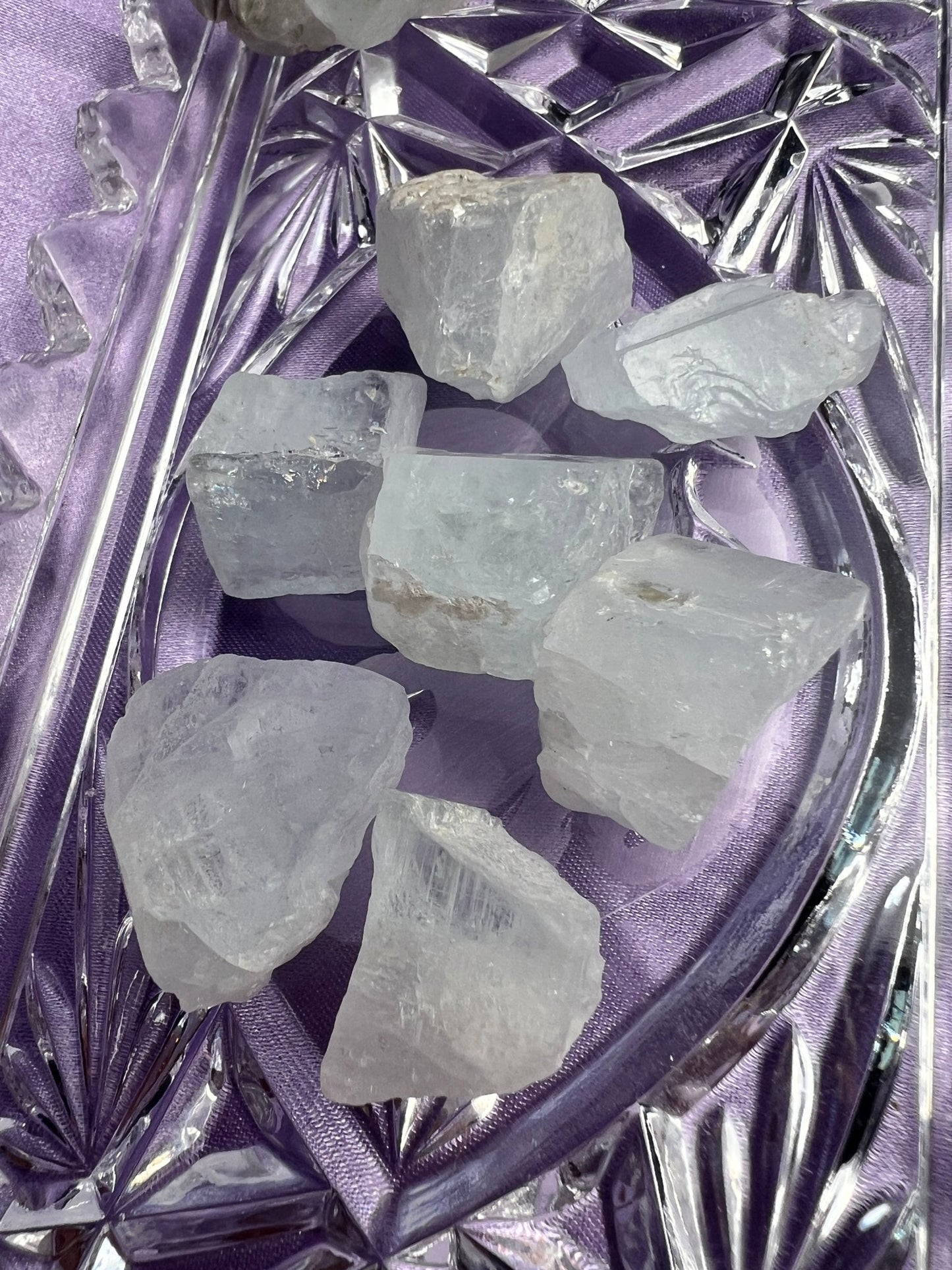 Raw crystals on a decorative purple plate with a textured background