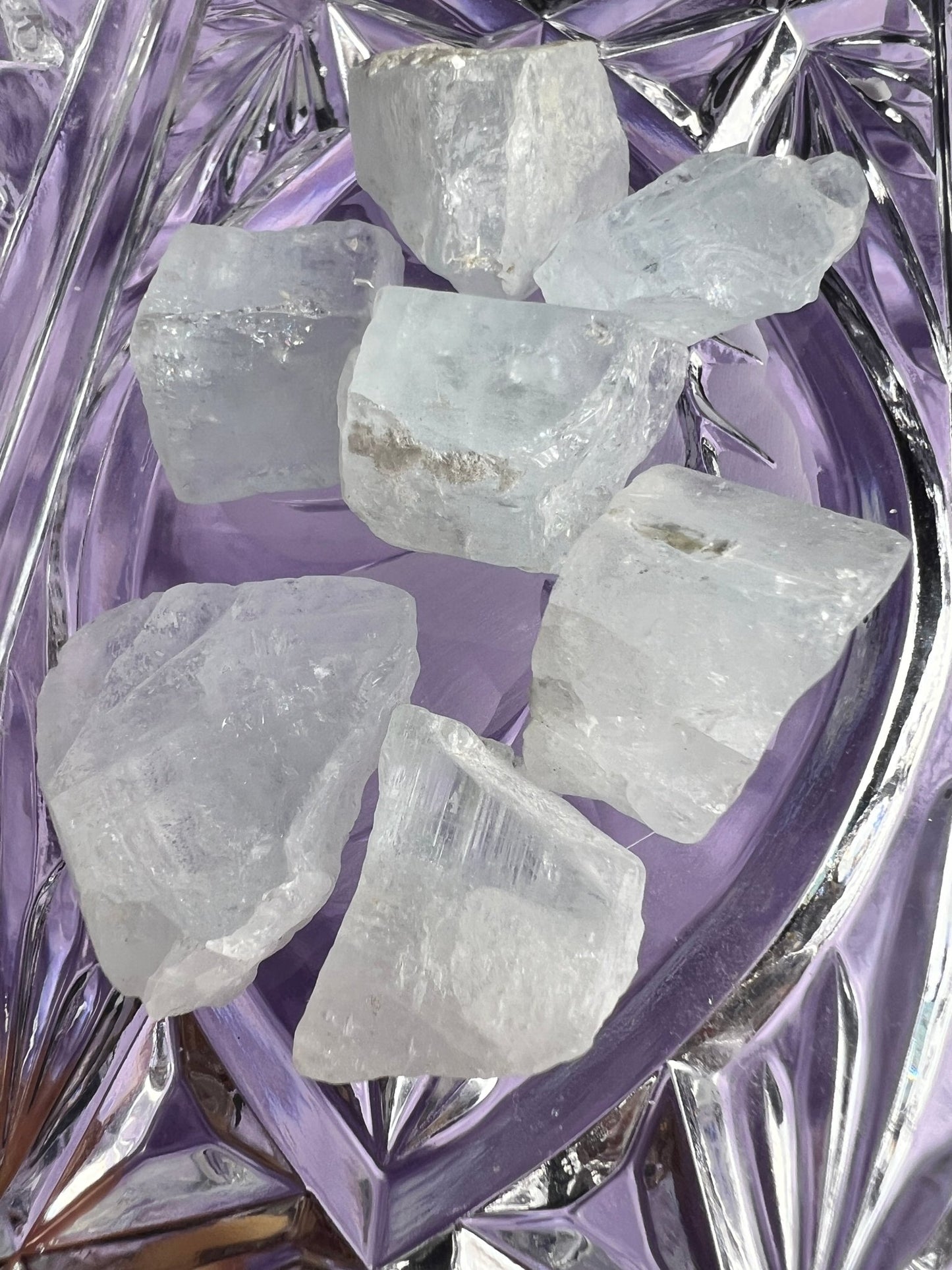 Raw diamonds on a purple crystal dish